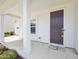 Inviting front porch with white columns, a dark door, and landscaped flower bed at 514 Bonville Ct, Fuquay Varina, NC 27526