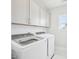 The laundry room features modern white appliances, white cabinetry and large window at 514 Bonville Ct, Fuquay Varina, NC 27526