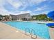 Community pool with splash pad area, water slide, lounge seating and is surrounded by mature trees at 514 Bonville Ct, Fuquay Varina, NC 27526