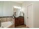Bright bathroom featuring a vessel sink on a granite countertop and tiled shower and jacuzzi at 5501 Southern Cross Ave, Raleigh, NC 27606