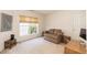 A well lit bedroom with a cozy loveseat and light carpet at 5501 Southern Cross Ave, Raleigh, NC 27606