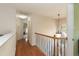 Bright upstairs hallway with hardwood floors and railing at 5501 Southern Cross Ave, Raleigh, NC 27606