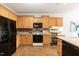 Kitchen boasts ample wood cabinets, black appliances, and a tiled backsplash at 5501 Southern Cross Ave, Raleigh, NC 27606