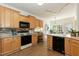 Well-lit kitchen with wooden cabinets, a breakfast bar, and stainless steel appliances at 5501 Southern Cross Ave, Raleigh, NC 27606