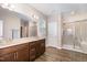 A full bathroom features a shower and a double sink vanity with great lighting at 59 White Quartz Pl, Fuquay Varina, NC 27526
