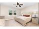 This bedroom offers neutral walls, a ceiling fan, windows, and is furnished with a comfy bed and side tables at 59 White Quartz Pl, Fuquay Varina, NC 27526