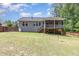 Exterior view of home, showcasing a screened porch and a large backyard with mature trees and a privacy fence at 59 White Quartz Pl, Fuquay Varina, NC 27526