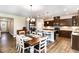 Open-concept kitchen and dining area boasts a large island, stainless appliances, and modern lighting at 59 White Quartz Pl, Fuquay Varina, NC 27526