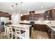 Bright kitchen features a large island with seating, stainless steel appliances, and dark wood cabinets at 59 White Quartz Pl, Fuquay Varina, NC 27526