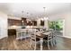 Open kitchen with stainless appliances, granite counters, tile backsplash, and dark wood cabinets at 59 White Quartz Pl, Fuquay Varina, NC 27526