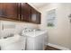 The spacious laundry room is equipped with modern appliances and ample cabinet storage at 59 White Quartz Pl, Fuquay Varina, NC 27526