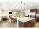 Open living space featuring kitchen island, dining area, and cozy fireplace with large TV screen at 59 White Quartz Pl, Fuquay Varina, NC 27526