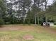 Large backyard featuring mature trees, open space, and a storage shed at 6300 Nc 27, Coats, NC 27521