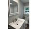 Bathroom featuring white vanity, modern faucet, toilet, and a window with natural light at 6300 Nc 27, Coats, NC 27521