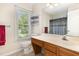 Bathroom featuring a toilet, vanity with sink, large mirror, and a view of the bathtub/shower combo at 809 Maple Shade Ln, Apex, NC 27502