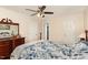 Bedroom featuring a blue floral bedspread, wooden dresser and nightstand, and multiple closet doors at 809 Maple Shade Ln, Apex, NC 27502