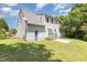 Back exterior of home with a deck, small door, and lush trees at 809 Maple Shade Ln, Apex, NC 27502