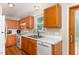 Kitchen featuring wood cabinets, white appliances, and view to the outside at 809 Maple Shade Ln, Apex, NC 27502