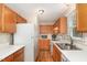 This is a view of the kitchen with wooden cabinets, white countertops and a double stainless steel sink at 809 Maple Shade Ln, Apex, NC 27502