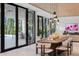 Elegant dining area with modern light fixtures and access to an outdoor pool and patio at 812 Stradella Rd, Raleigh, NC 27614