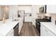 Bright kitchen featuring white cabinets, quartz countertops, stainless steel appliances, and hardwood floors at 817 Ottawa Dr, Garner, NC 27529