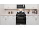 Modern kitchen with white cabinets, quartz countertops, stainless steel appliances, and a subway tile backsplash at 817 Ottawa Dr, Garner, NC 27529