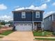 Charming two-story home featuring a blue exterior and a two-car garage, enhanced by a neatly manicured lawn at 825 Ottawa Dr, Garner, NC 27529