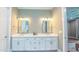 Bright bathroom featuring double sinks, white cabinets, and a doorway to Primary bedroom suite at 98102 Drummond, Chapel Hill, NC 27517