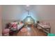 Bright bonus room with a sloped ceiling features hardwood floors, a day bed, seating, and a white vanity desk at 98102 Drummond, Chapel Hill, NC 27517