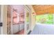 View of the covered deck with wooden ceiling and outdoor fan with living room viewable through the french doors at 98102 Drummond, Chapel Hill, NC 27517