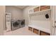 A well-organized laundry room with modern washer and dryer, built-in storage, and tiled floors at 98102 Drummond, Chapel Hill, NC 27517
