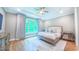 Comfortable bedroom with neutral walls, hardwood floors, ceiling fan, and a large window with natural light at 98102 Drummond, Chapel Hill, NC 27517