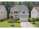 Two-story home featuring a well-manicured lawn, mature trees, and a two-car garage at 1008 Justice Walk Ave, Morrisville, NC 27560