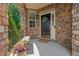 Welcoming stone porch featuring a bench, wreath, and a black front door at 1008 Justice Walk Ave, Morrisville, NC 27560