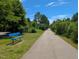 Scenic greenway trail with a blue bench, inviting residents to relax and enjoy the natural surroundings at 1008 Justice Walk Ave, Morrisville, NC 27560