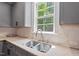Kitchen features gray cabinets, granite countertops, stainless steel sink and a window view at 1008 Justice Walk Ave, Morrisville, NC 27560