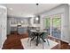The kitchen features gray cabinets, an island, and a breakfast nook with a view to a sunroom at 1008 Justice Walk Ave, Morrisville, NC 27560