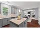 Modern kitchen with stainless steel dishwasher, light gray cabinets, and an island with seating at 1008 Justice Walk Ave, Morrisville, NC 27560