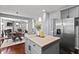 Open kitchen with stainless steel refrigerator, island, and views of the breakfast and living areas at 1008 Justice Walk Ave, Morrisville, NC 27560