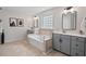 Relaxing main bathroom showcasing a soaking tub, tile accents, and modern gray cabinetry at 1008 Justice Walk Ave, Morrisville, NC 27560