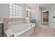 Bright main bathroom with a soaking tub, modern fixtures, and easy access to the closet at 1008 Justice Walk Ave, Morrisville, NC 27560