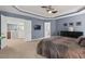 Spacious main bedroom featuring a tray ceiling, neutral carpet, and a wall-mounted television at 1008 Justice Walk Ave, Morrisville, NC 27560