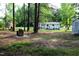 View of the backyard of home with cinderblock fire pit and shed in a wooded backyard at 10180 Buffalo Rd, Clayton, NC 27527