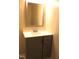 Updated bathroom featuring a gray vanity, sink, modern faucet and large framed mirror at 10180 Buffalo Rd, Clayton, NC 27527