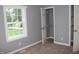 Comfortable bedroom featuring neutral carpet, gray walls, closet and a window with a wooded view at 10180 Buffalo Rd, Clayton, NC 27527