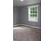 Comfortable bedroom featuring neutral carpet, gray walls and a window with a wooded view at 10180 Buffalo Rd, Clayton, NC 27527