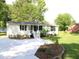Charming home featuring fresh landscaping, a cozy front porch, and a new driveway at 10180 Buffalo Rd, Clayton, NC 27527