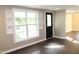 Living room featuring hardwood floors, a large window with built-in shelves, and a black door at 10180 Buffalo Rd, Clayton, NC 27527