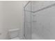 Step-in shower featuring white tile and glass door in a bathroom with tiled floors at 1027 Holden Rd, Youngsville, NC 27596