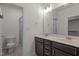 Bathroom featuring double sink vanity, decorative mirror and a step-in shower with tile surround at 1027 Holden Rd, Youngsville, NC 27596